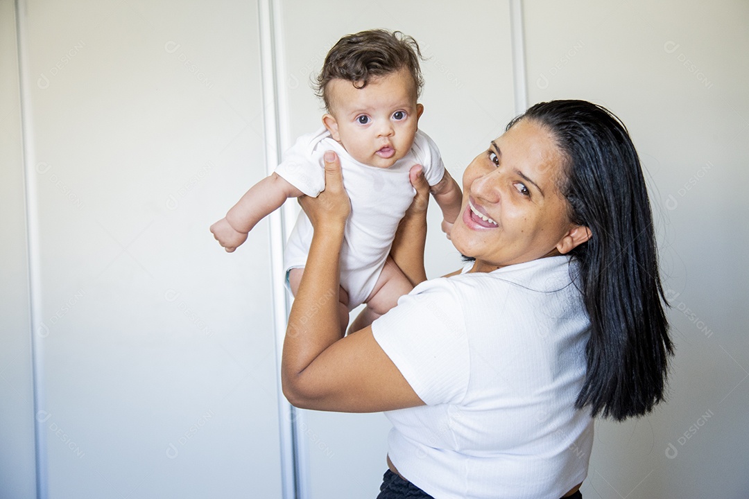 Mãe jovem cuidadando de seu filho sobre quarto