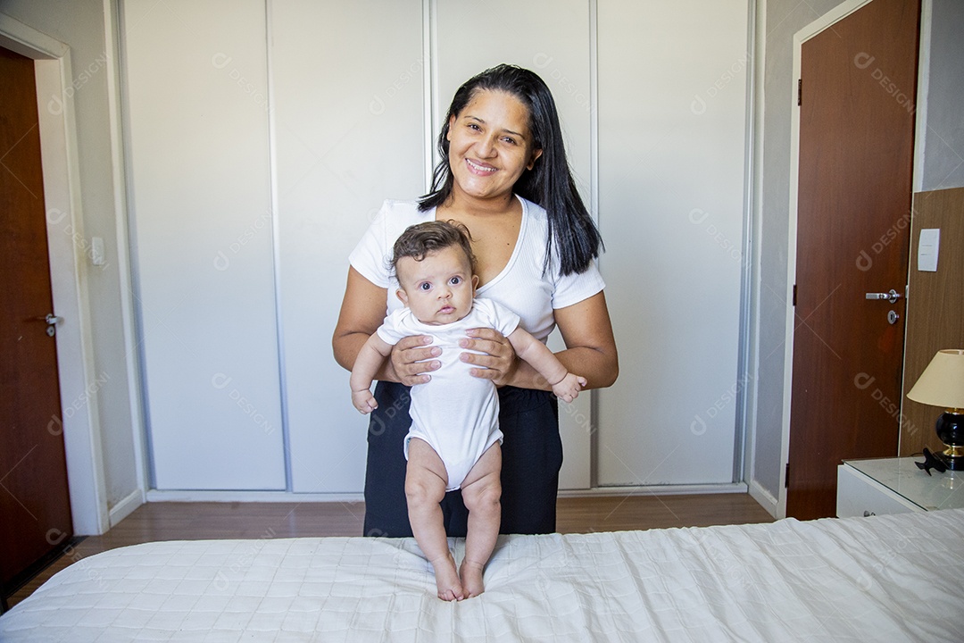 Mãe jovem cuidadando de seu filho sobre quarto