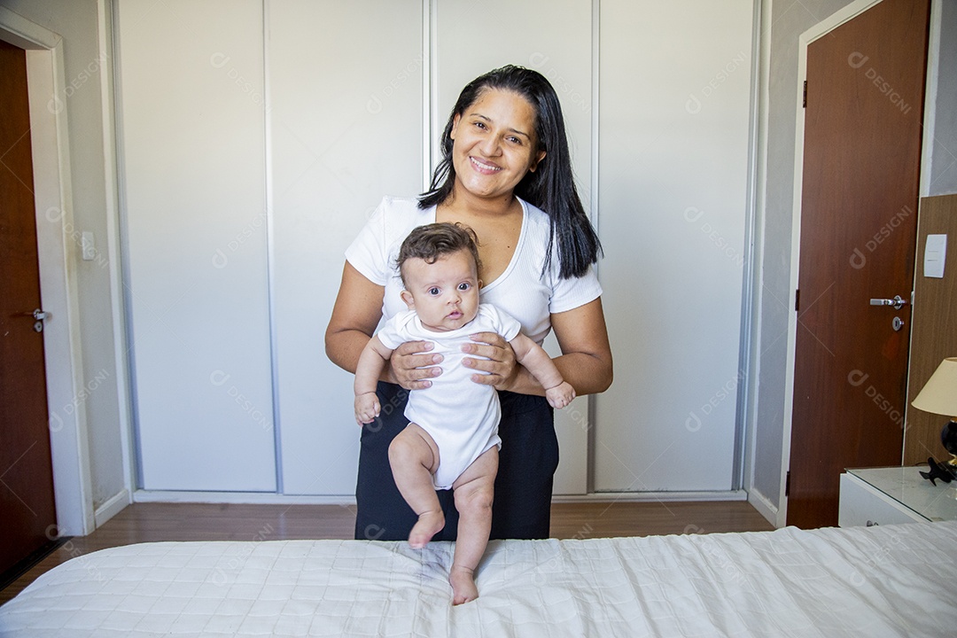 Mãe jovem cuidadando de seu filho sobre quarto