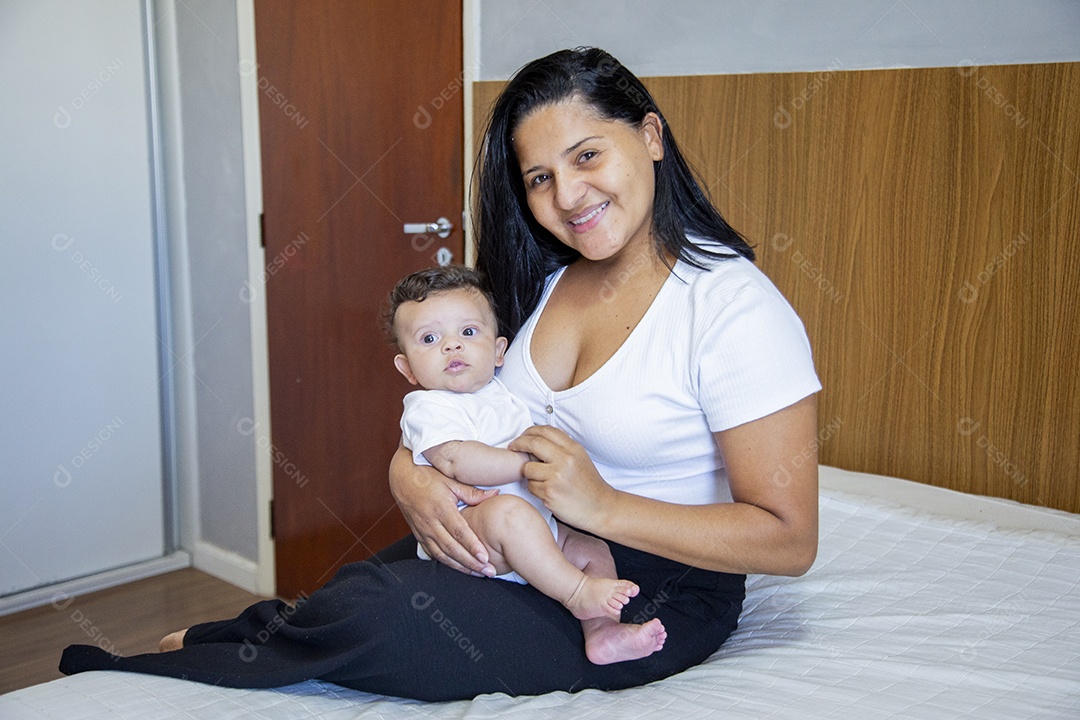 Mãe jovem cuidadando de seu filho sobre quarto