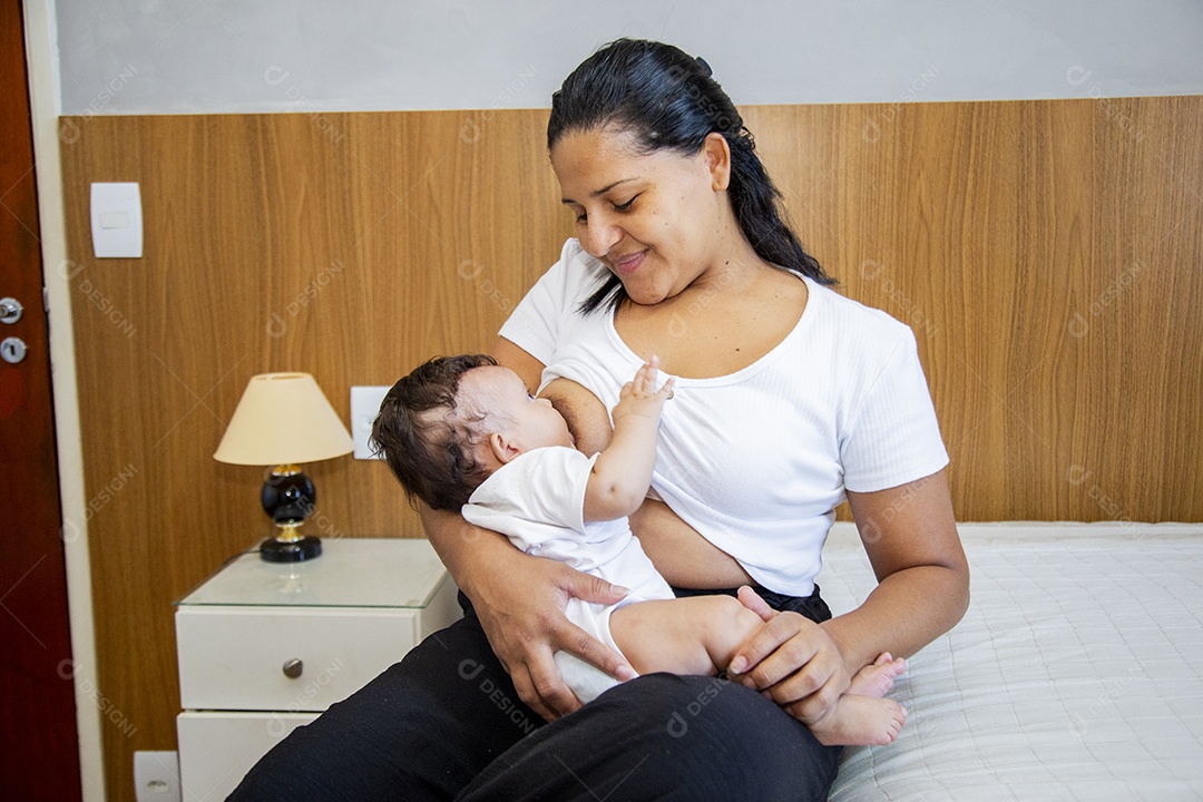 Mãe jovem amamentando seu filho sobre quarto
