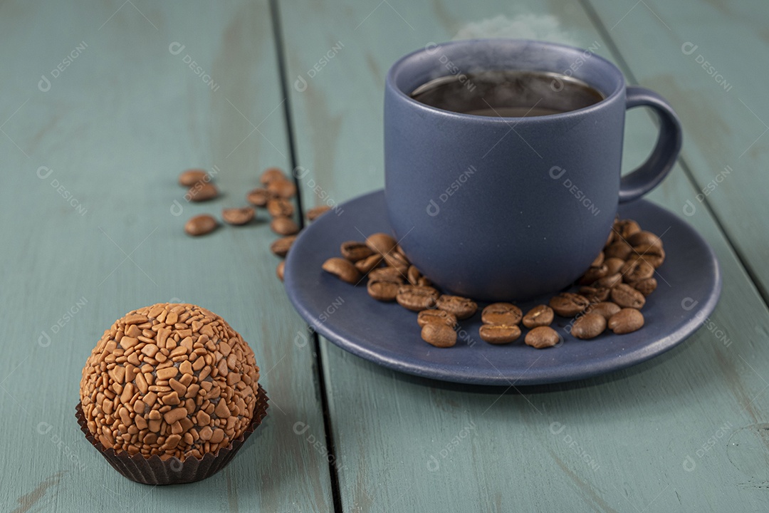 Brigadeiro e xícara de café e grãos ao lado