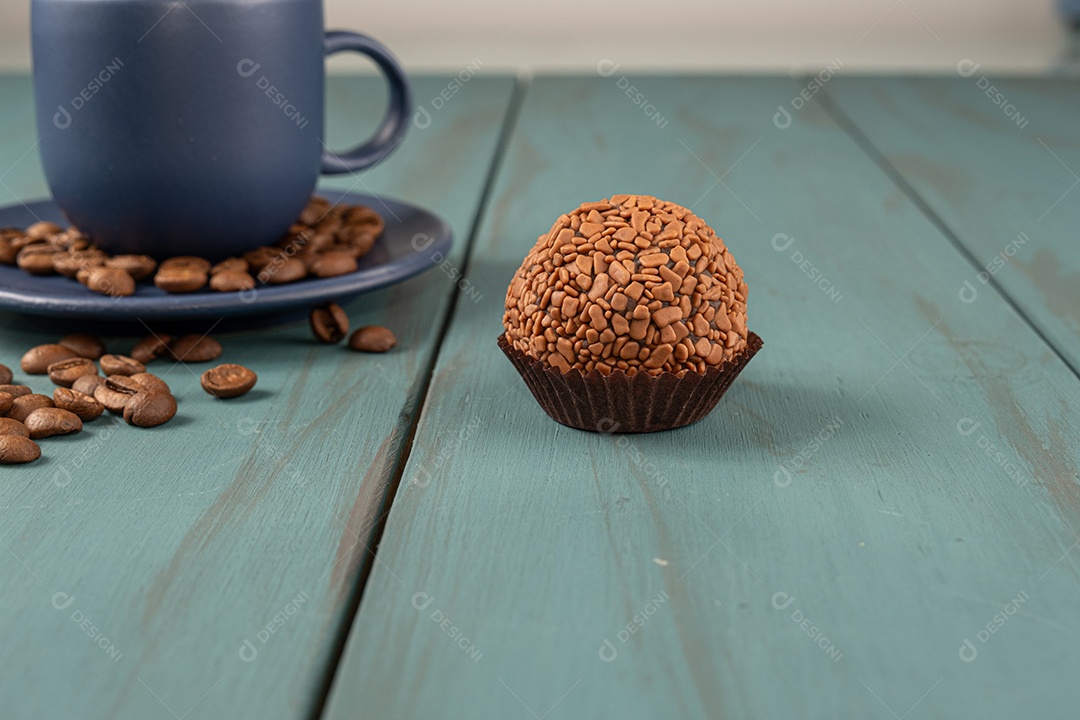 Brigadeiro de chocolate e xícara de café de fundo