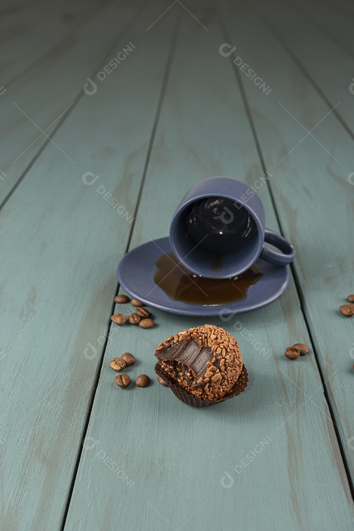 Brigadeiro de chocolate e xícara de café de fundo