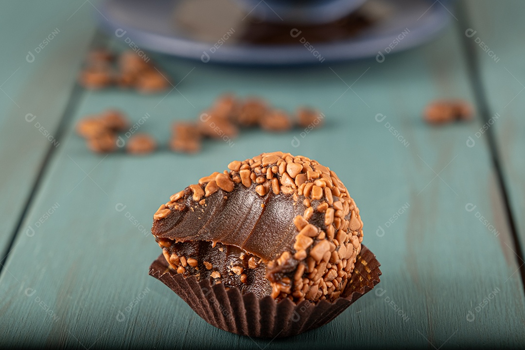 Brigadeiro de chocolate com grãos de café ao fundo