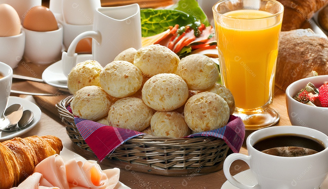 Café da manhã com pão de queijo e suco sobre a mesa
