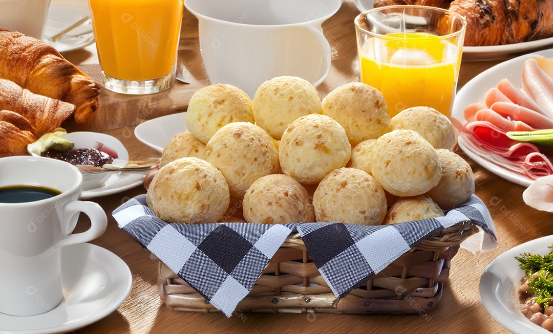 Cesta com pães de queijo em mesa de café da manhã