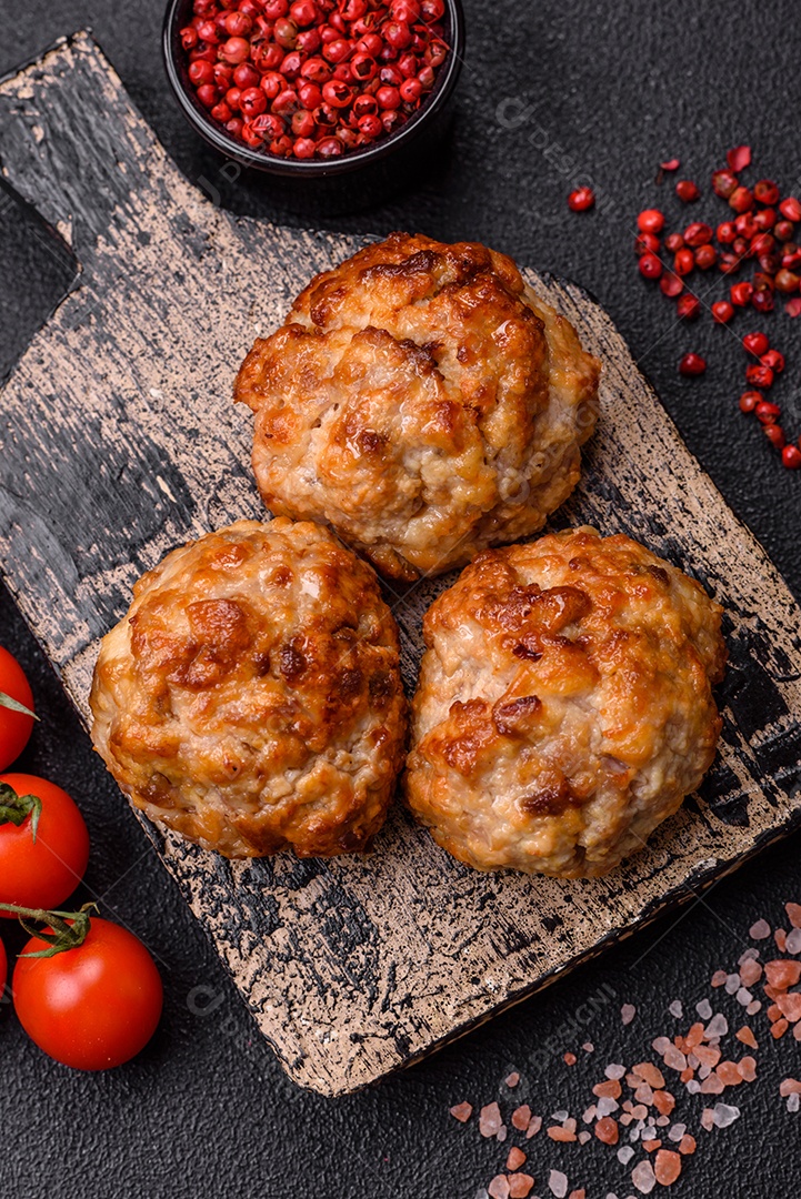 Deliciosas costeletas de peixe picado frito fresco com especiarias e ervas sobre um fundo escuro de concreto