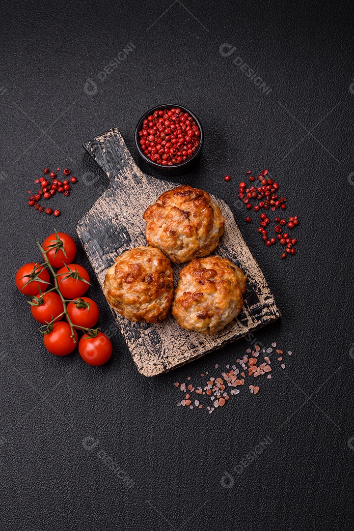 Deliciosas costeletas de peixe picado frito fresco com especiarias e ervas sobre um fundo escuro de concreto