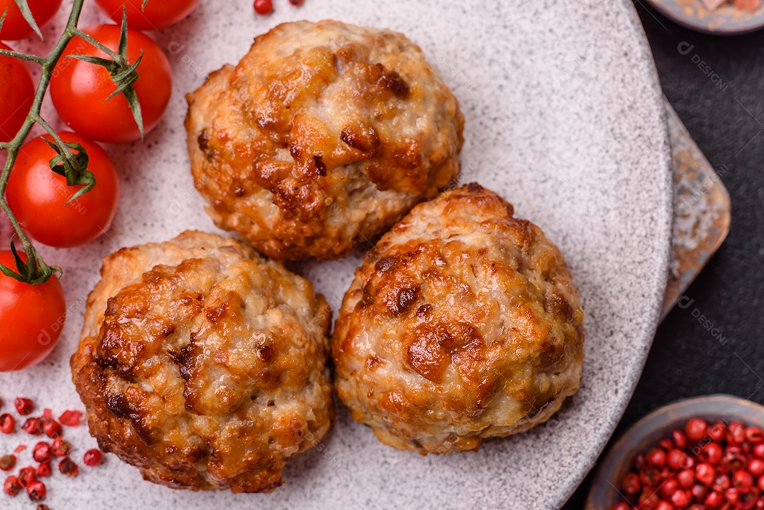 Deliciosas costeletas de peixe picado frito fresco com especiarias e ervas sobre um fundo escuro de concreto