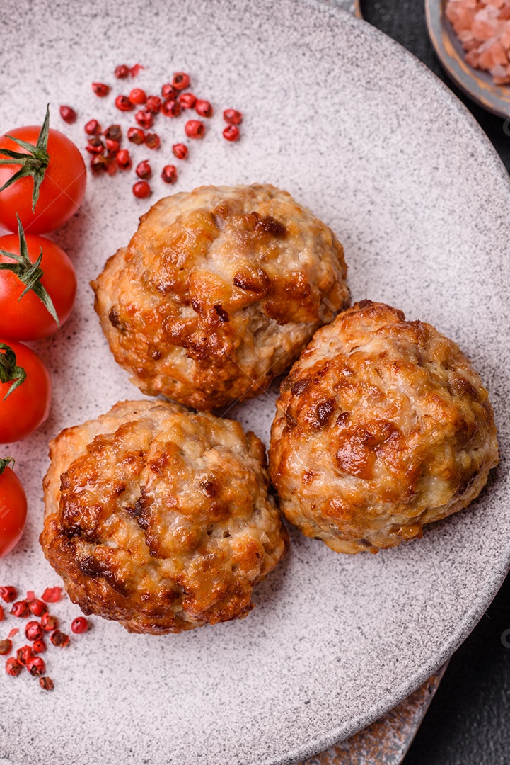 Deliciosas costeletas de peixe picado frito fresco com especiarias e ervas sobre um fundo escuro de concret