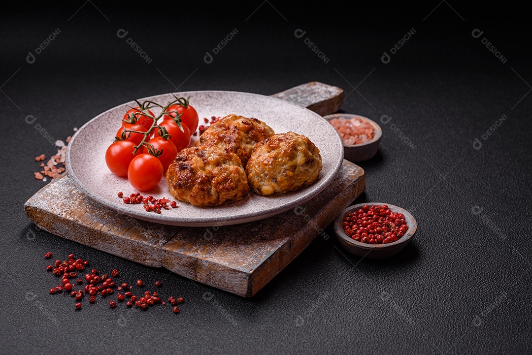Deliciosas costeletas de peixe picado frito fresco com especiarias e ervas sobre um fundo escuro de concreto