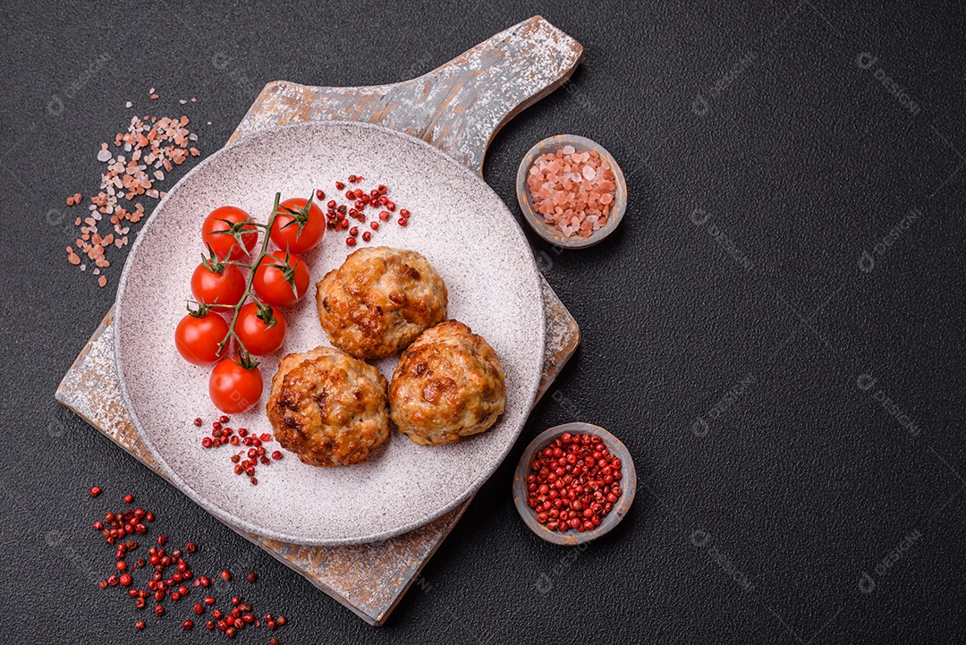 Deliciosas costeletas de peixe picado frito fresco com especiarias e ervas sobre um fundo escuro de concreto