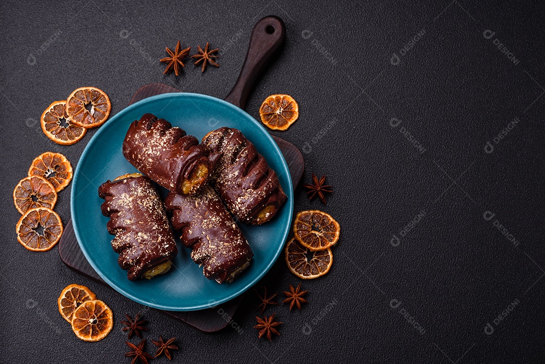 Deliciosos bolos de chocolate doce com recheio de frutas e granulados em uma placa de cerâmica sobre um fundo escuro de concreto