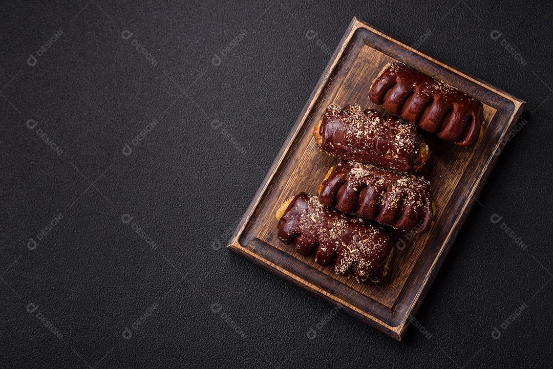 Deliciosos bolos de chocolate doce com recheio de frutas e granulados em uma placa de cerâmica sobre um fundo escuro de concreto