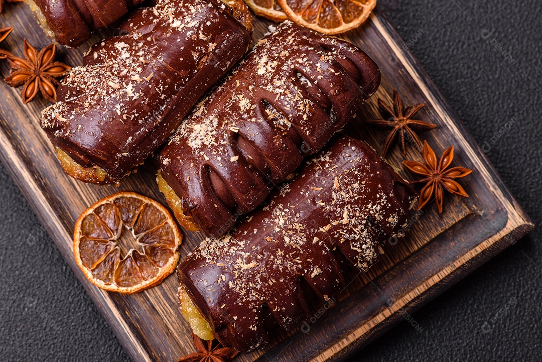 Deliciosos bolos de chocolate doce com recheio de frutas e granulados em uma placa de cerâmica sobre um fundo escuro de concreto