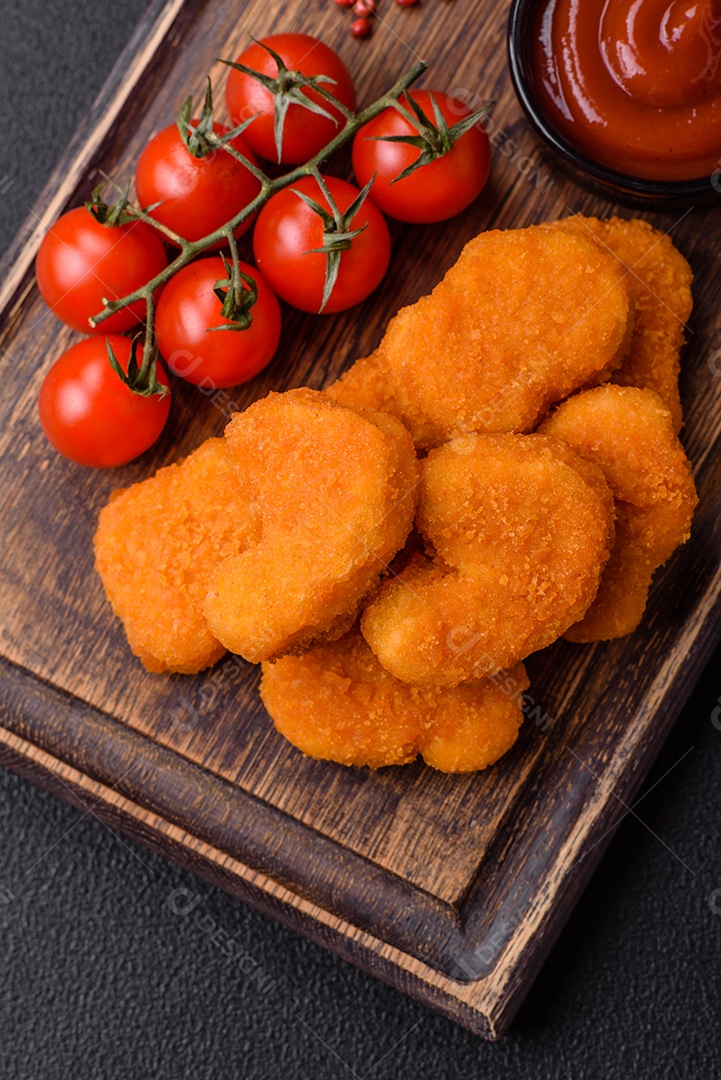 Deliciosos nuggets de frango crocantes frescos em um fundo escuro de concreto. Alimentos não saudáveis, fast food