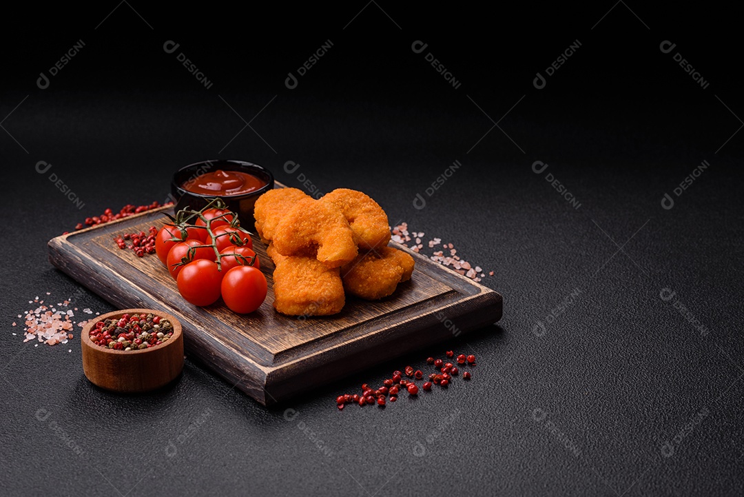 Deliciosos nuggets de frango crocantes frescos em um fundo escuro de concreto. Alimentos não saudáveis, fast food