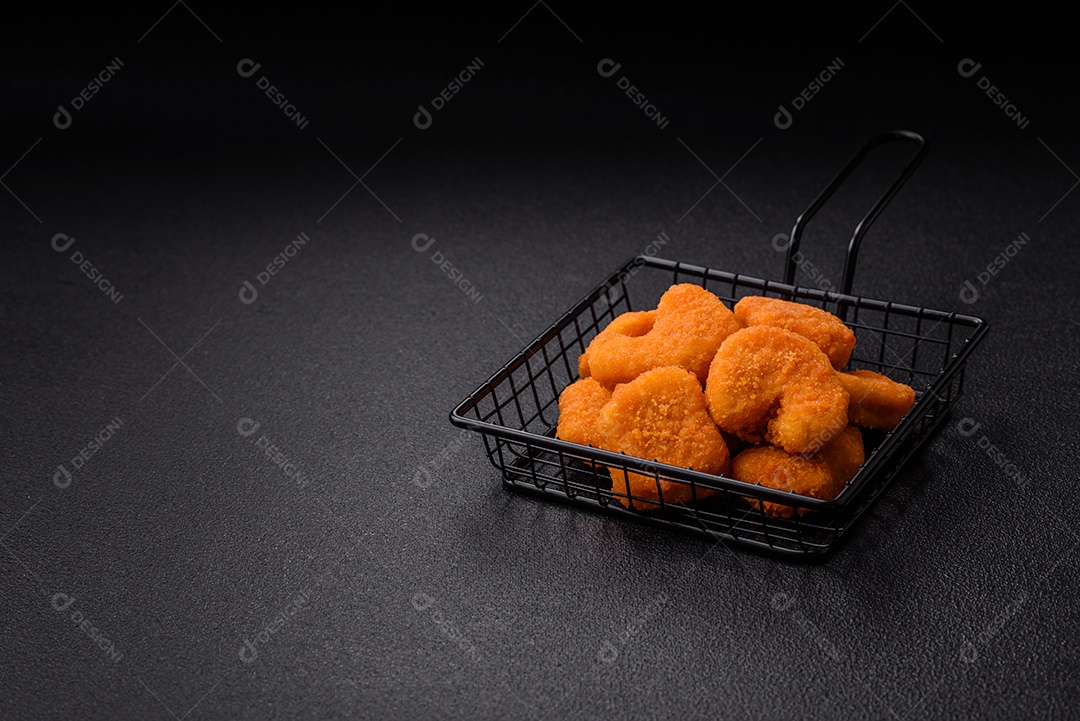 Deliciosos nuggets de frango crocantes frescos em um fundo escuro de concreto. Alimentos não saudáveis, fast food