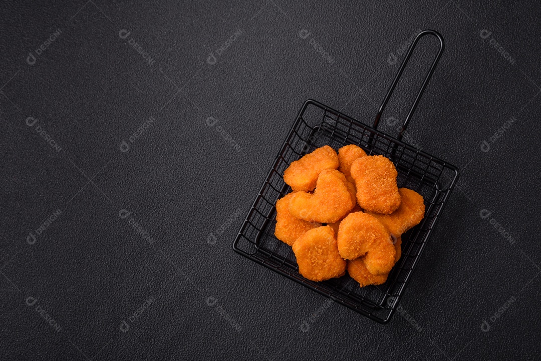 Deliciosos nuggets de frango crocantes frescos em um fundo escuro de concreto. Alimentos não saudáveis, fast food