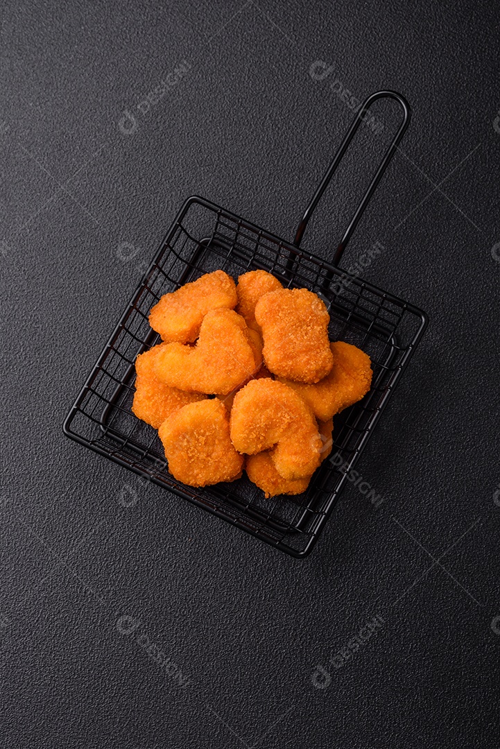 Deliciosos nuggets de frango crocantes frescos em um fundo escuro de concreto. Alimentos não saudáveis, fast food