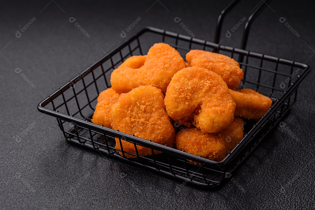 Deliciosos nuggets de frango crocantes frescos em um fundo escuro de concreto. Alimentos não saudáveis, fast food