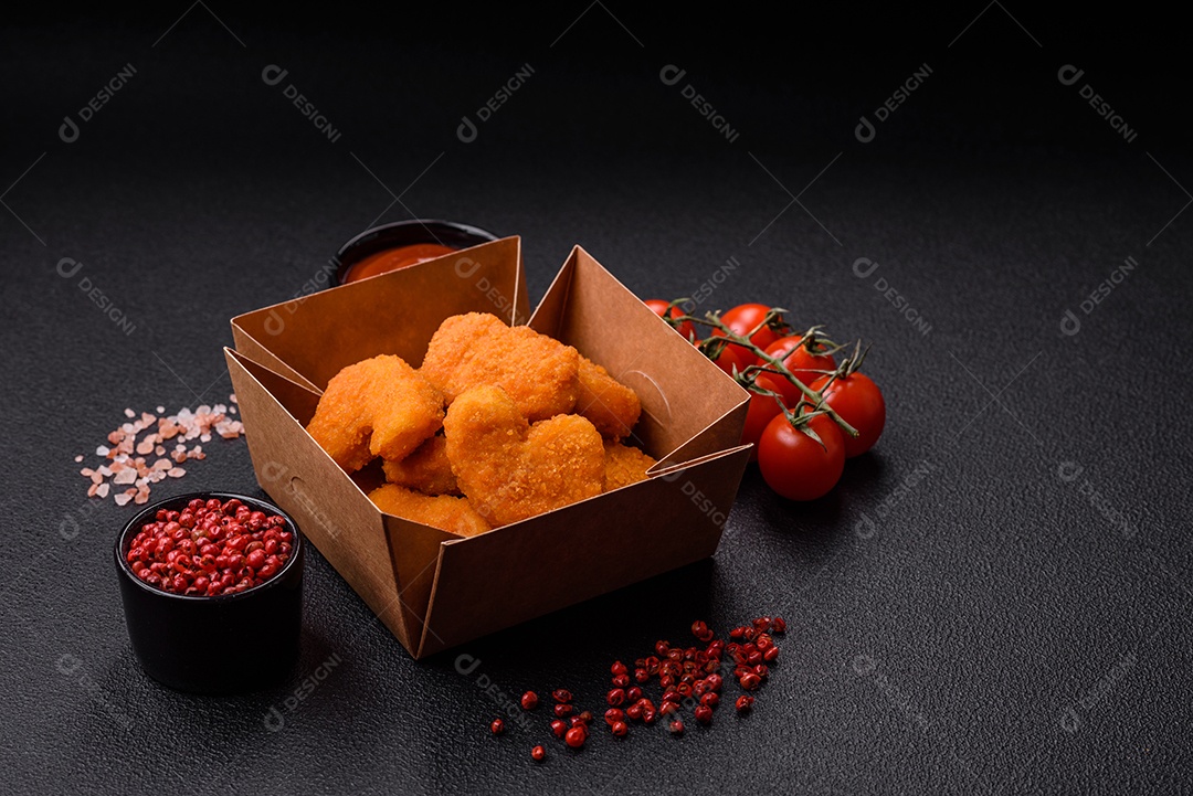 Deliciosos nuggets de frango crocantes frescos em um fundo escuro de concreto. Alimentos não saudáveis, fast food