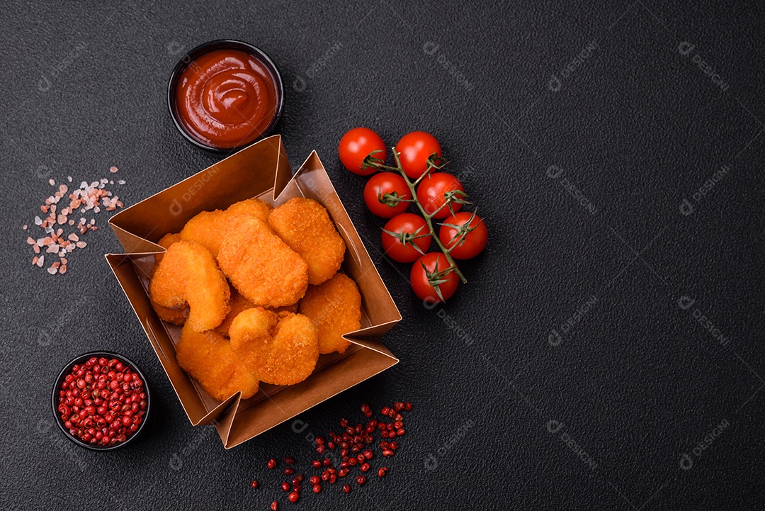 Deliciosos nuggets de frango crocantes frescos em um fundo escuro de concreto. Alimentos não saudáveis, fast food