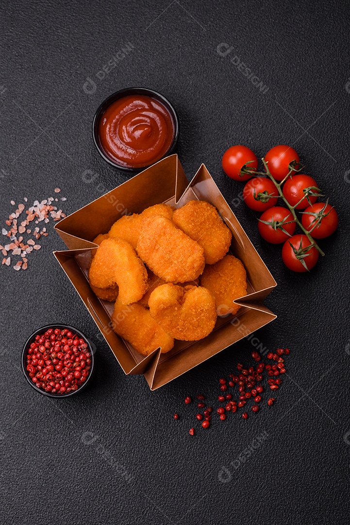 Deliciosos nuggets de frango crocantes frescos em um fundo escuro de concreto. Alimentos não saudáveis, fast food