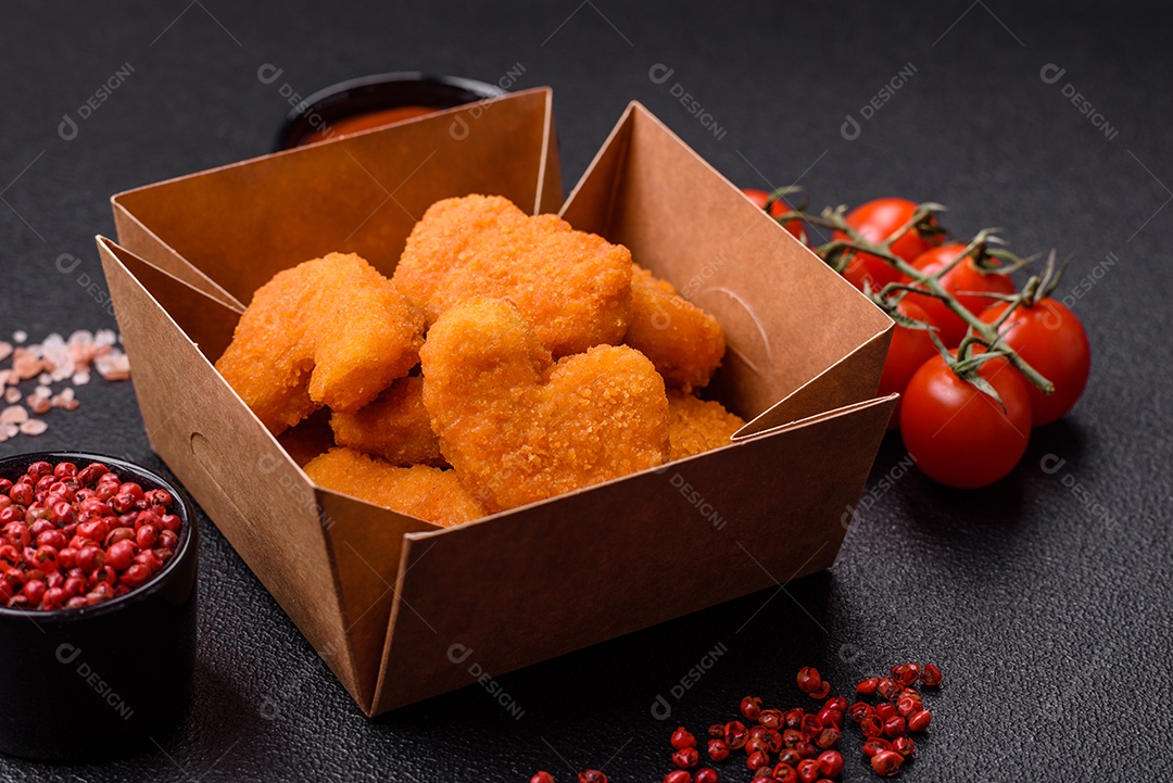 Deliciosos nuggets de frango crocantes frescos em um fundo escuro de concreto. Alimentos não saudáveis, fast food