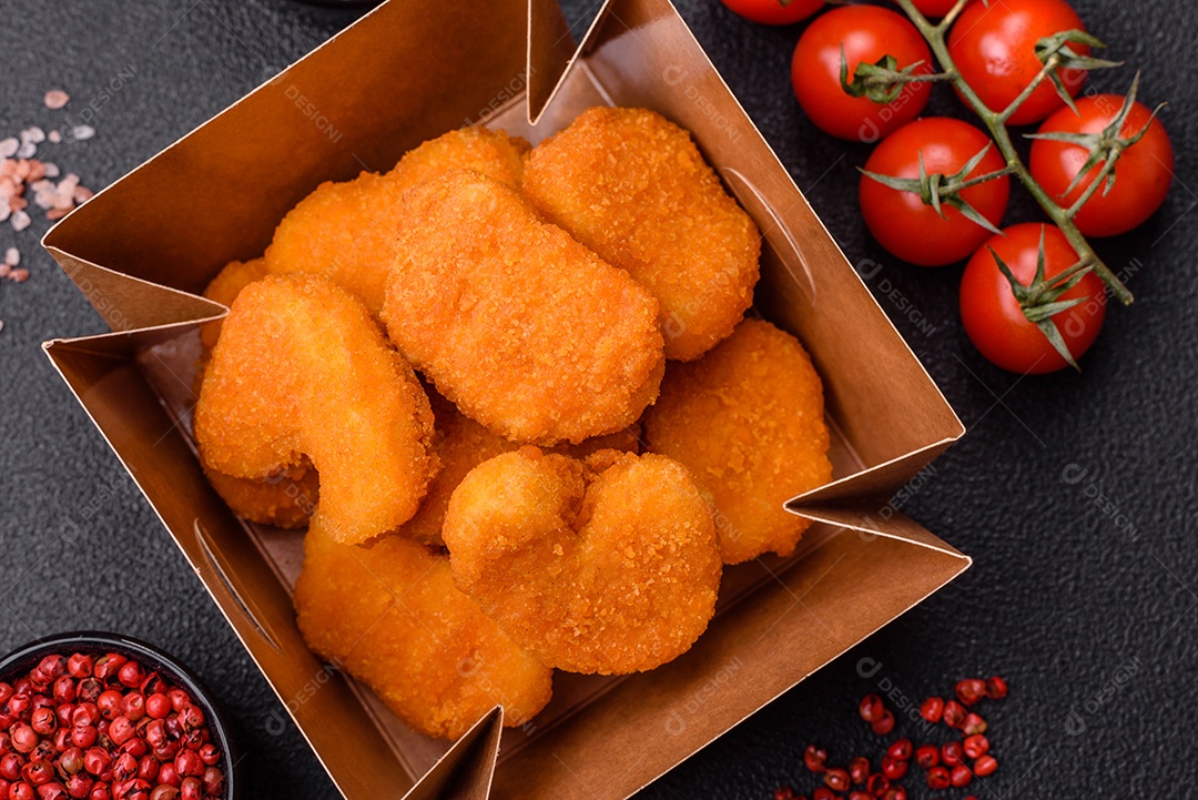 Deliciosos nuggets de frango crocantes frescos em um fundo escuro de concreto. Alimentos não saudáveis, fast food