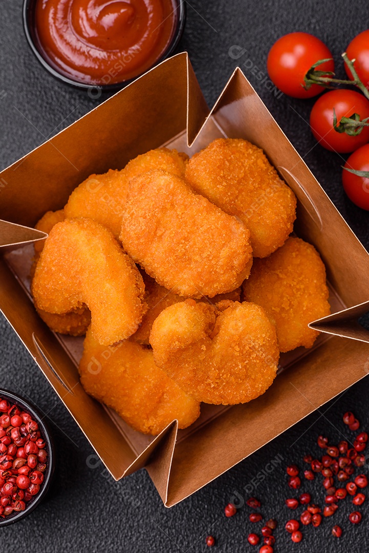 Deliciosos nuggets de frango crocantes frescos em um fundo escuro de concreto. Alimentos não saudáveis, fast food