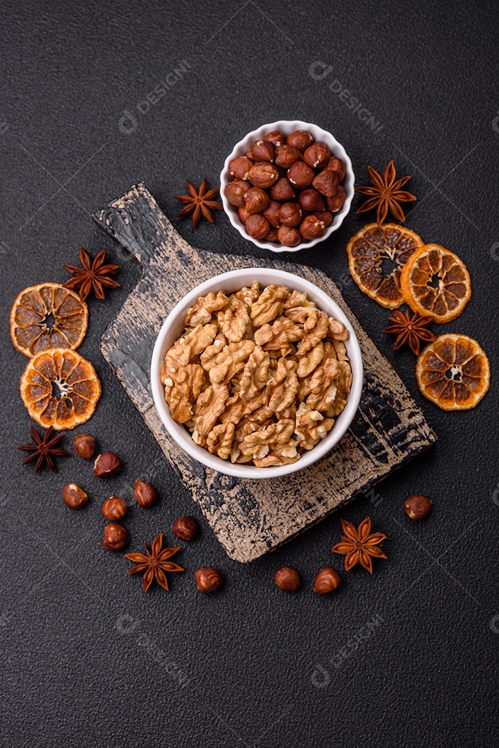 Deliciosas nozes cruas descascadas frescas em uma placa cerâmica sobre um fundo escuro de concreto