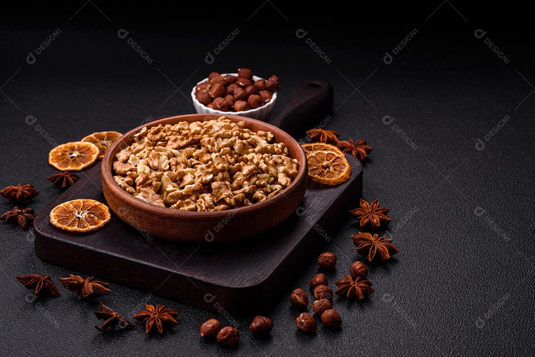 Deliciosas nozes cruas descascadas frescas em uma placa cerâmica sobre um fundo escuro de concreto