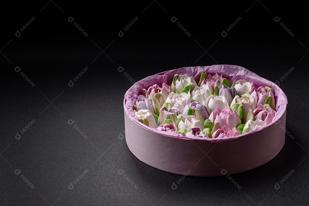 Lindos e saborosos marshmallows em forma de botões de tulipa sobre um fundo escuro de concreto