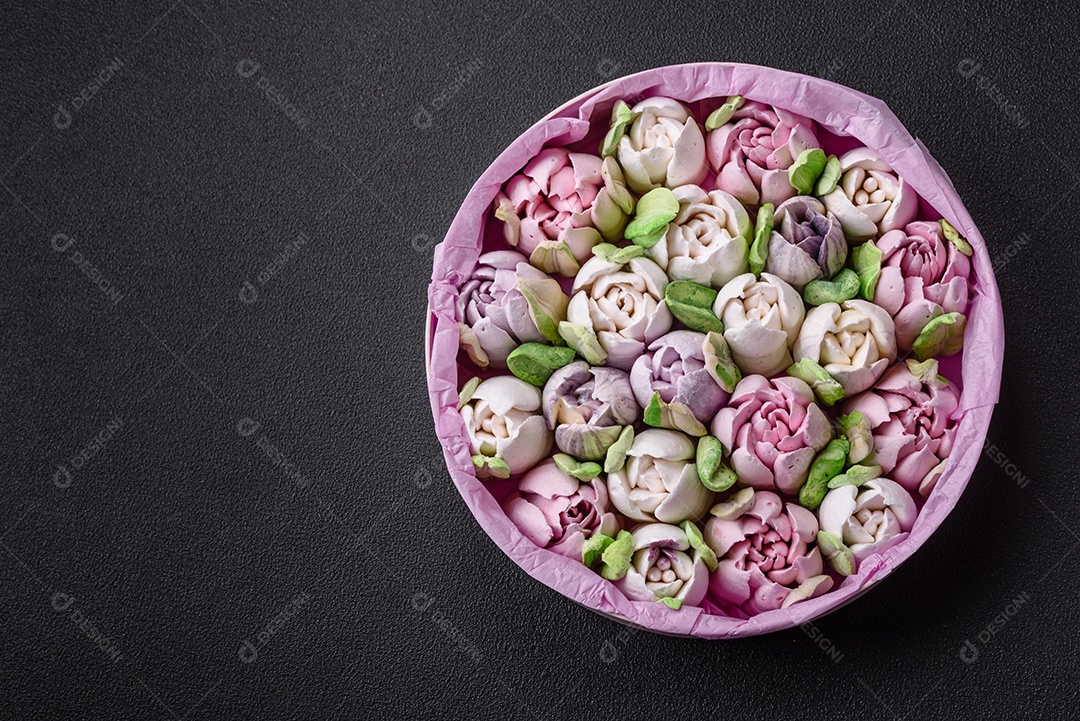 Lindos e saborosos marshmallows em forma de botões de tulipa sobre um fundo escuro de concreto