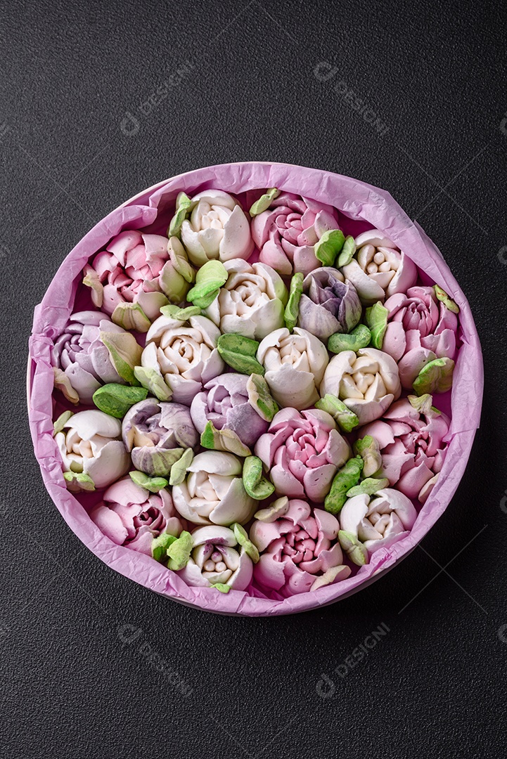 Lindos e saborosos marshmallows em forma de botões de tulipa sobre um fundo escuro de concreto