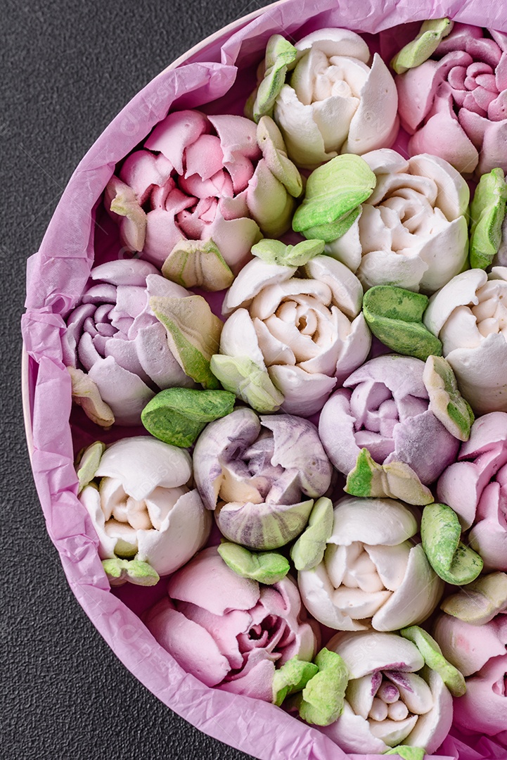 Lindos e saborosos marshmallows em forma de botões de tulipa sobre um fundo escuro de concreto
