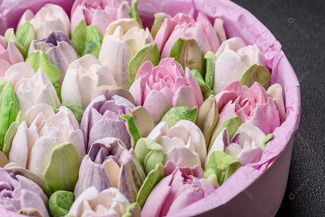 Lindos e saborosos marshmallows em forma de botões de tulipa sobre um fundo escuro de concreto