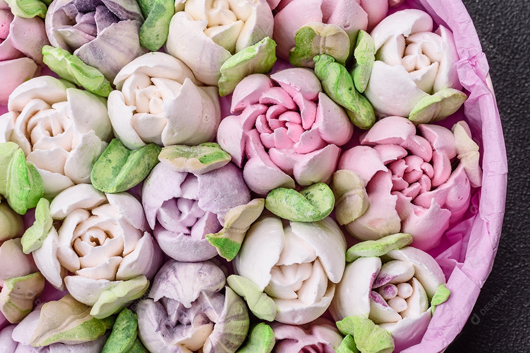Lindos e saborosos marshmallows em forma de botões de tulipa sobre um fundo escuro de concreto