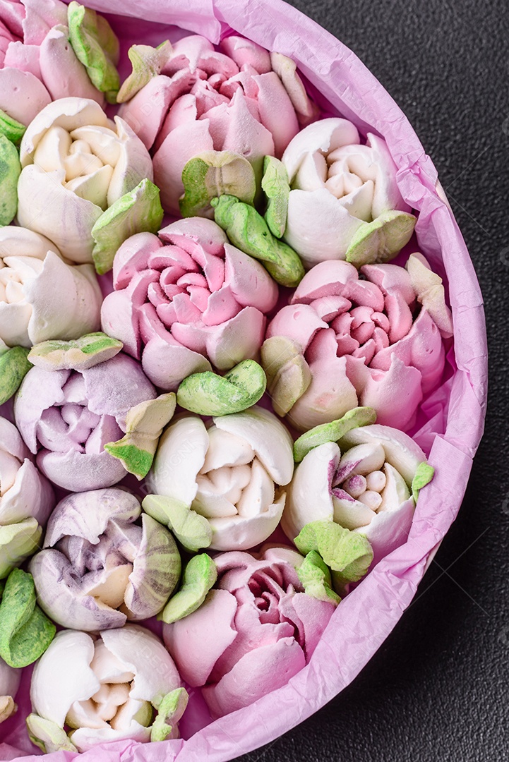 Lindos e saborosos marshmallows em forma de botões de tulipa sobre um fundo escuro de concreto
