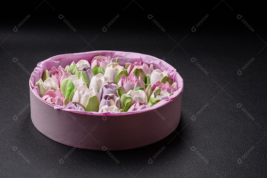 Lindos e saborosos marshmallows em forma de botões de tulipa sobre um fundo escuro de concreto