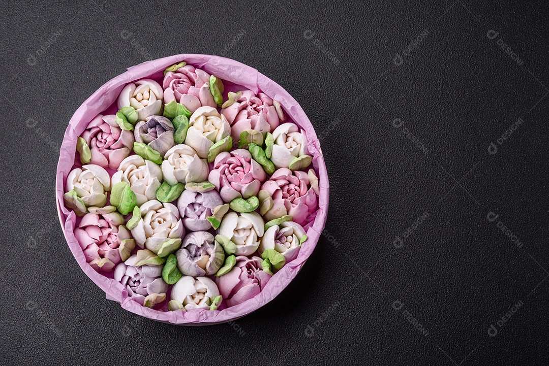 Lindos e saborosos marshmallows em forma de botões de tulipa sobre um fundo escuro de concreto
