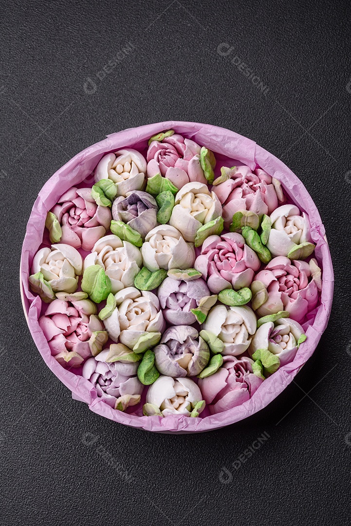 Lindos e saborosos marshmallows em forma de botões de tulipa sobre um fundo escuro de concreto