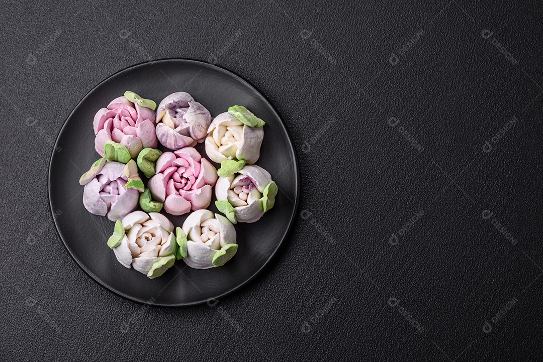 Lindos e saborosos marshmallows em forma de botões de tulipa sobre um fundo escuro de concreto