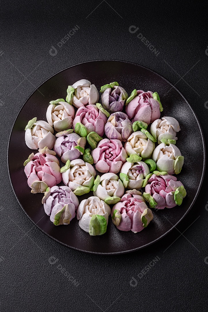 Lindos e saborosos marshmallows em forma de botões de tulipa sobre um fundo escuro de concreto