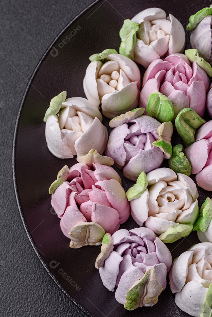 Lindos e saborosos marshmallows em forma de botões de tulipa sobre um fundo escuro de concreto