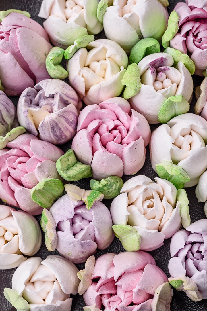 Lindos e saborosos marshmallows em forma de botões de tulipa sobre um fundo escuro de concreto