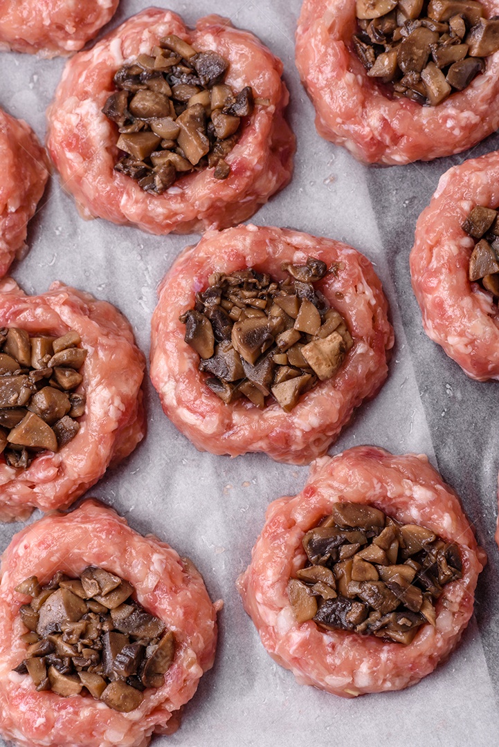Deliciosos barcos de carne assada com cogumelos, queijo, sal e especiarias sobre um fundo escuro de concreto