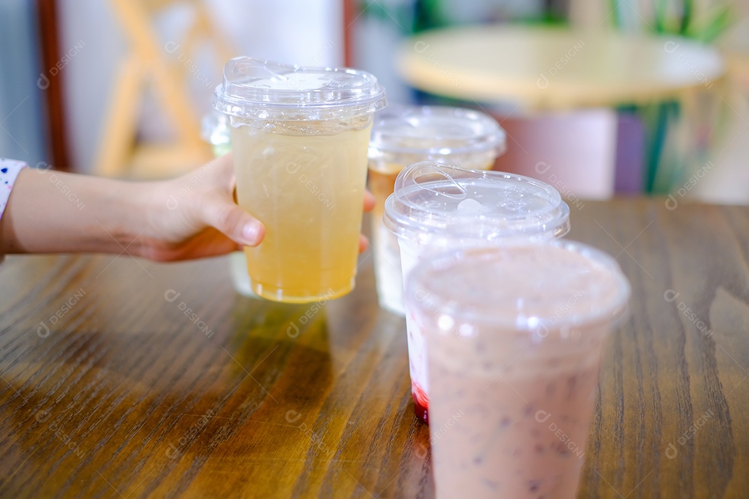 A mão da mulher segura um copo